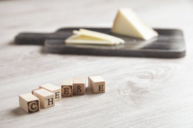 Wooden letters CHEESE in front of marble board