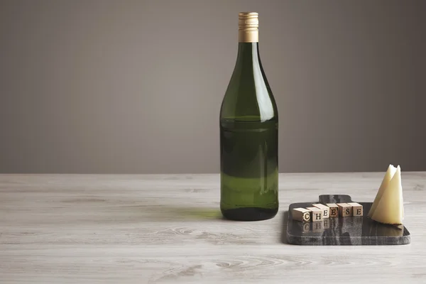 Weinflasche mit Buchstaben und Käse Seitenansicht — Stockfoto