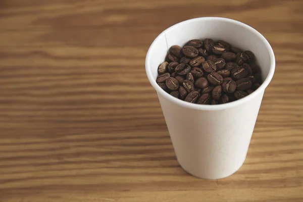 Blank white paper cup with good roasted coffee beans — Stockfoto
