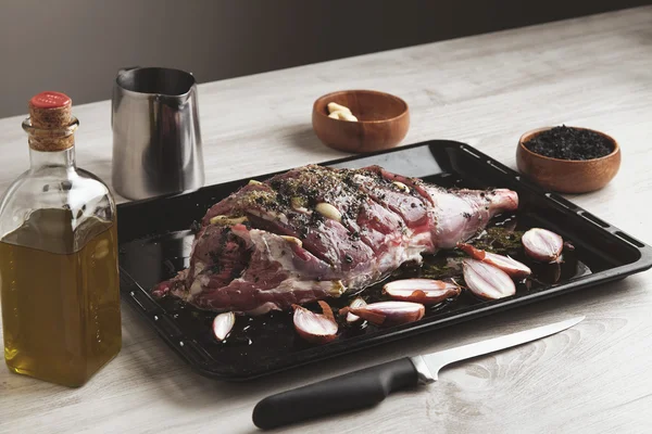 Pre cooked lamb leg on black roasting plate — Φωτογραφία Αρχείου