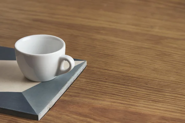 Tazza di caffè bianco bianco su piatto di ceramica su un tavolo di legno spesso — Foto Stock