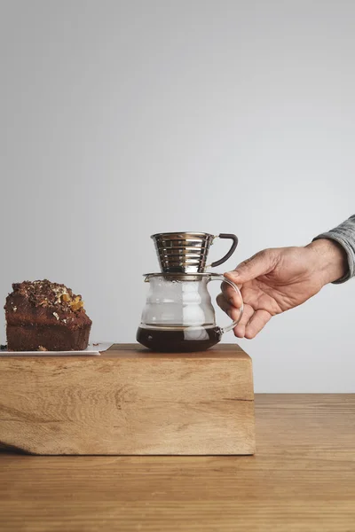 Schokoladenkuchen mit Tropfkaffeemaschine in Barista-Hand — Stockfoto