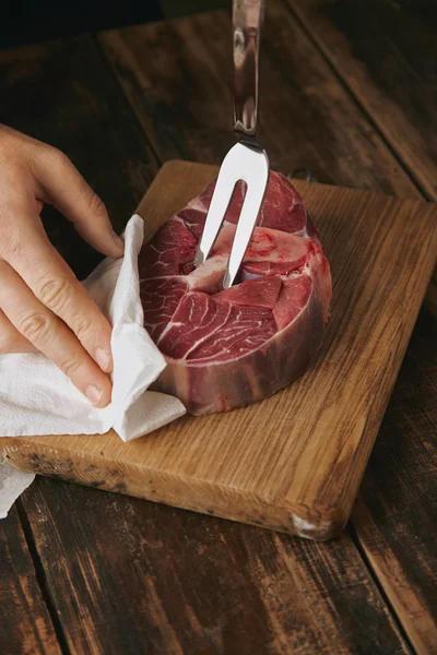 Garfo de carne close-up em bife cru — Fotografia de Stock