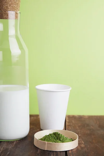 Milk bottle, matcha, paper glass on green back — Stock Photo, Image