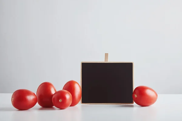 Haufen roter Tomaten mit Preisschild isoliert — Stockfoto