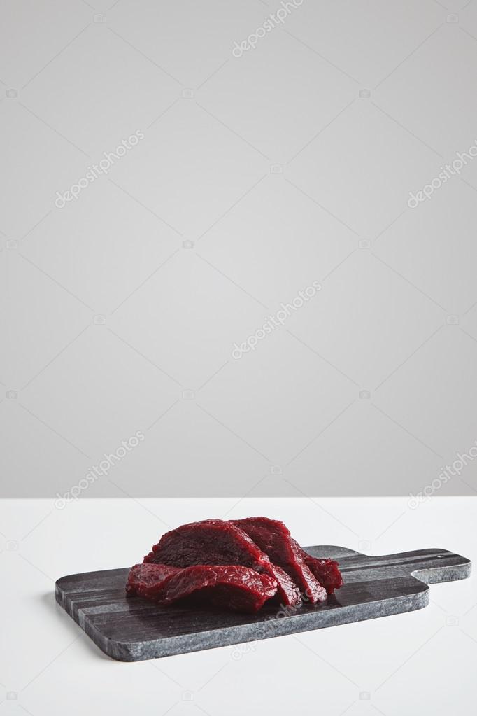 Sliced whale meat steak on marble board isolated