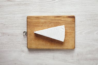 Beyaz masa üzerinde kesme tahtası üzerinde izole Brie
