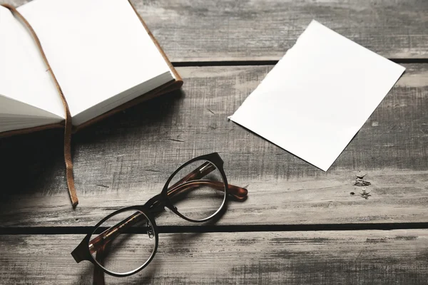 Cuaderno abierto, vasos, hoja de papel sobre mesa negra — Foto de Stock