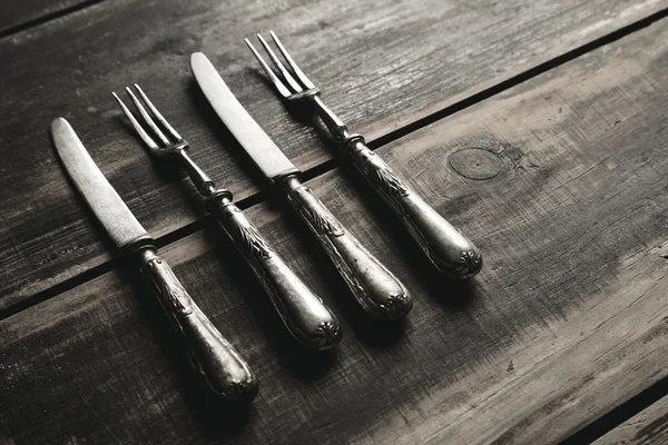 Tenedor y cuchillo sobre mesa negra — Foto de Stock