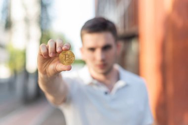 Küçük bir çocuk bitcoin kripto para gösteriyor. Genç Bitcoin yatırımcısı. Seçici odak