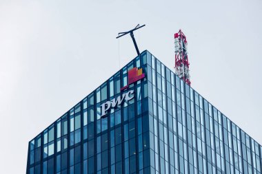 VIENNA, AUSTRIA - 31 Temmuz 2019 'da Viyana' daki Viyana Donau şehrindeki DC Kulesi 1 'in (Avusturya' nın en yüksek gökdelenidir) cam cephesi üzerine PricewaterhouseCoopers (PwC) logosu.