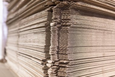 Parçalanmış karton yapraklar paletlerin üstüne yığın halinde - montajdan sonra karton kutular olacak. Endüstriyel üretimde bitmiş ürünlerin ambalajı.