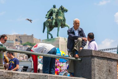 Napoli, İtalya - 27 Mayıs Akdeniz kıyısında yaz günü. İnsanlar rahatlar yürür, güneşlenir ve Monumento Armando Diaz yakınlarındaki deniz kenarında hayatın tadını çıkarırlar. 27 Mayıs 2012. Napoli, Campania, İtalya.