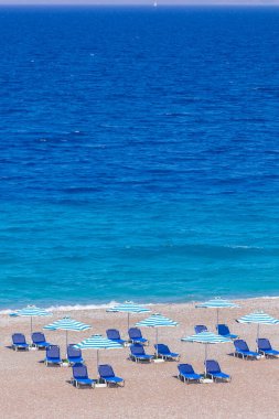 Boş bir sahil beldesinde renkli şemsiyeler ve güneşlikler - Ege ve Akdeniz 'deki Yunanistan adalarında tatil kavramı