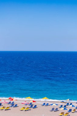 Boş bir sahil beldesinde renkli şemsiyeler ve güneşlikler - Ege ve Akdeniz 'deki Yunanistan adalarında tatil kavramı
