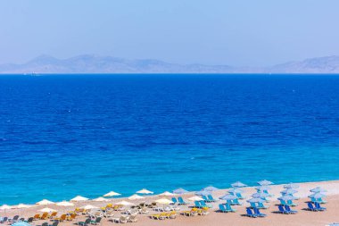 Boş bir sahil beldesinde renkli şemsiyeler ve güneşlikler - Ege ve Akdeniz 'deki Yunanistan adalarında tatil kavramı