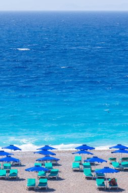 Boş bir sahil beldesinde renkli şemsiyeler ve güneşlikler - Ege ve Akdeniz 'deki Yunanistan adalarında tatil kavramı