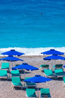 Boş bir sahil beldesinde renkli şemsiyeler ve güneşlikler - Ege ve Akdeniz 'deki Yunanistan adalarında tatil kavramı