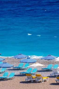 Boş bir sahil beldesinde renkli şemsiyeler ve güneşlikler - Ege ve Akdeniz 'deki Yunanistan adalarında tatil kavramı