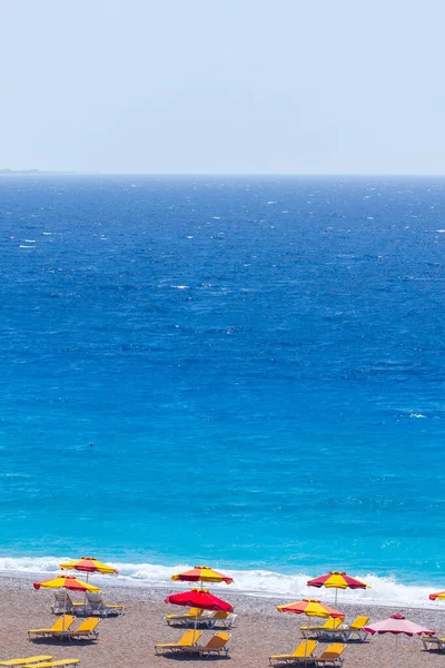 一个空旷海滩度假胜地的彩色雨伞和日光浴床 爱琴海和地中海希腊岛屿度假概念 — 图库照片