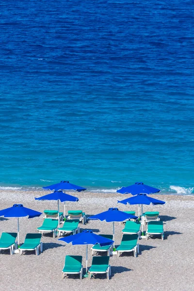 一个空旷海滩度假胜地的彩色雨伞和日光浴床 爱琴海和地中海希腊岛屿度假概念 — 图库照片