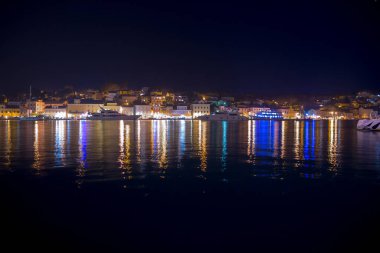 Mali Losinj limanı ve limanının eski Mali Losinj kasabasındaki gece manzarası. Limandaki lüks yatlar, tekneler ve diğer gemiler. Adriyatik Denizi 'ndeki Hırvat adalarında yaz tatili.