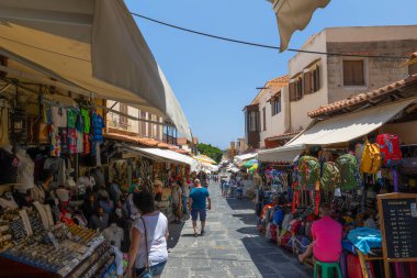 Rhodes, Yunanistan - 28 Haziran 2021: Sıcak yaz güneşli öğleden sonra turistik bir yer. Eski Rhodes Kasabası 'ndaki Sokrates Caddesi. Dükkanlar, restoranlar, yüzlerce turist ve tatilci..