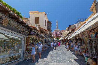 Rhodes, Yunanistan - 28 Haziran 2021: Sıcak yaz güneşli öğleden sonra turistik bir yer. Eski Rhodes Kasabası 'ndaki Sokrates Caddesi. Dükkanlar, restoranlar, yüzlerce turist ve tatilci..