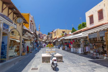 Rhodes, Yunanistan - 28 Haziran 2021: Sıcak yaz güneşli öğleden sonra turistik bir yer. Eski Rhodes Kasabası 'ndaki Sokrates Caddesi. Dükkanlar, restoranlar, yüzlerce turist ve tatilci..
