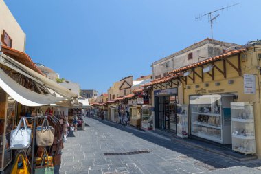 Rhodes, Yunanistan - 28 Haziran 2021: Sıcak yaz güneşli öğleden sonra turistik bir yer. Eski Rhodes Kasabası 'ndaki Sokrates Caddesi. Dükkanlar, restoranlar, yüzlerce turist ve tatilci..