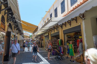 Rhodes, Yunanistan - 28 Haziran 2021: Sıcak yaz güneşli öğleden sonra turistik bir yer. Eski Rhodes Kasabası 'ndaki Sokrates Caddesi. Dükkanlar, restoranlar, yüzlerce turist ve tatilci..