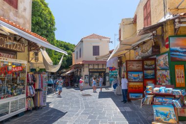Rhodes, Yunanistan - 28 Haziran 2021: Sıcak yaz güneşli öğleden sonra turistik bir yer. Eski Rhodes Kasabası 'ndaki Sokrates Caddesi. Dükkanlar, restoranlar, yüzlerce turist ve tatilci..