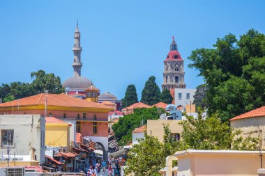 Rodos, Yunanistan - 29 Haziran 2021: Sıcak yaz güneşli öğleden sonra turistik bir yer. Eski Rhodes Kasabası 'ndaki Sokrates Caddesi. Dükkanlar, restoranlar, yüzlerce turist ve tatilci..
