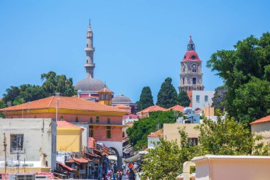Rodos, Yunanistan - 29 Haziran 2021: Sıcak yaz güneşli öğleden sonra turistik bir yer. Eski Rhodes Kasabası 'ndaki Sokrates Caddesi. Dükkanlar, restoranlar, yüzlerce turist ve tatilci..