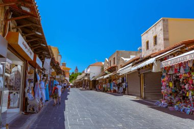 Rodos, Yunanistan - 4 Temmuz 2021: Sıcak yaz güneşli öğleden sonra manzaralı bir yer. Eski Rhodes Kasabası 'ndaki Sokrates Caddesi. Dükkanlar, restoranlar, yüzlerce turist ve tatilci..