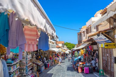Rodos, Yunanistan - 4 Temmuz 2021: Sıcak yaz güneşli öğleden sonra manzaralı bir yer. Eski Rhodes Kasabası 'ndaki Sokrates Caddesi. Dükkanlar, restoranlar, yüzlerce turist ve tatilci..