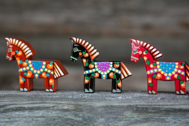 İki kırmızı ve bir siyah ahşap oyuncaklar (atlar)
