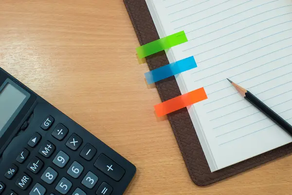 Pencil,note paper,calculator and notebook on wooden table. on Top — Stock Photo, Image