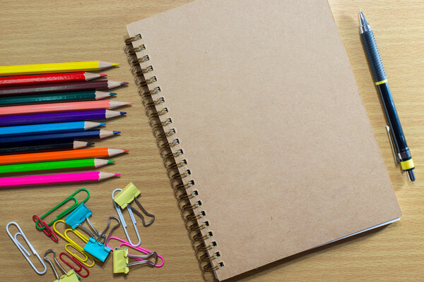 Blank notebook on school and frame of colorful school supplies