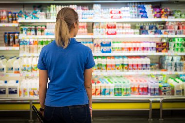 genç bir kadın supermaket, raf satın almak için seçin