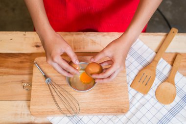 Kadın prepeared yumurta tahta masada yemek pişirmek için