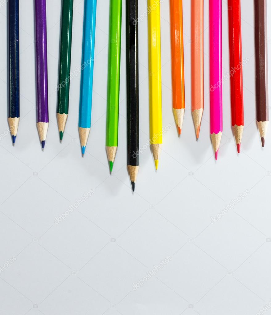 Multi colored pencils  on a white background with space for text