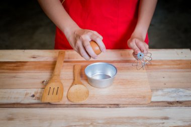 Kadın prepeared yumurta tahta masada yemek pişirmek için