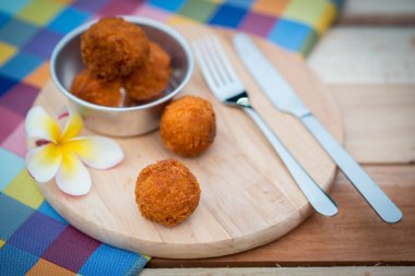 Derin kızarmış peynir topu üzerinde ahşap tabak