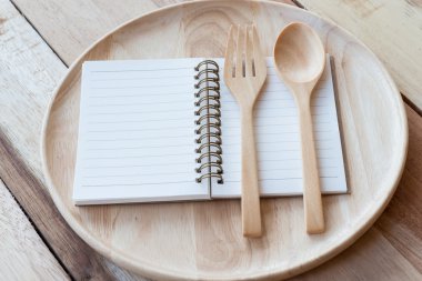 ahşap tabak, ahşap çatal ve defter üzerinde ahşap table.with metin alanı
