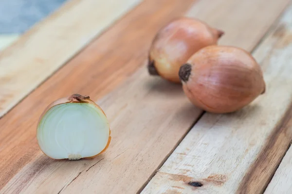 Cebollas sobre tabla de madera — Foto de Stock