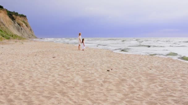 Chicas jóvenes felices están mirando el mar en la playa, estilo de vida familiar de verano. — Vídeos de Stock