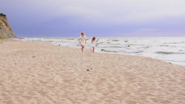 Gelukkige jonge meisjes lopen op het strand, zomer familie levensstijl. — Stockvideo