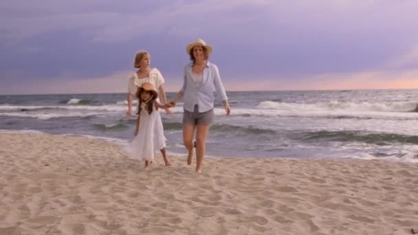 Bonitas hermanas hijas en la playa con madre sonriente. — Vídeos de Stock