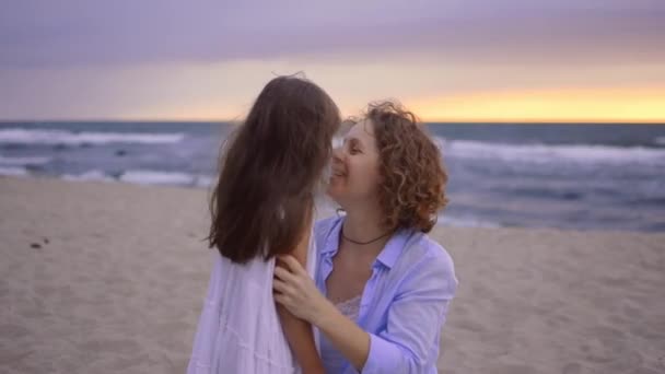 Feliz madre está abrazando a su pequeña hija en la playa. — Vídeos de Stock